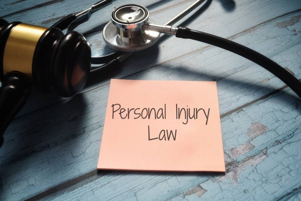 Personal injury law black writing on postit with gavel and stethoscope in background
