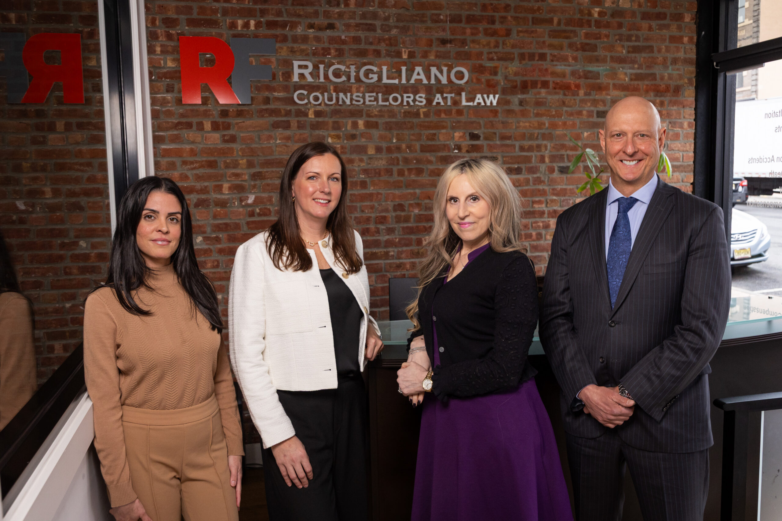 RF Injury Law crew smiling in front of logo